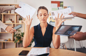 A women pushes away papers due to stress and overwork.